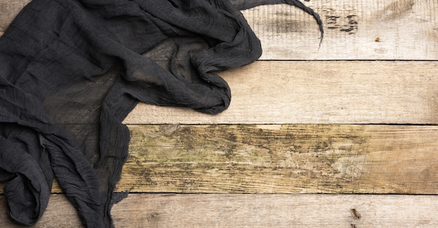 Serviette De Gaze Noire Pliée Sur Une Table Faite De Vieilles Planches En Bois Gris, Vue Du Dessus, Copiez L'espace