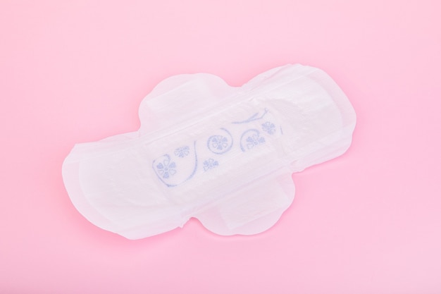 Serviette hygiénique sur une surface rose