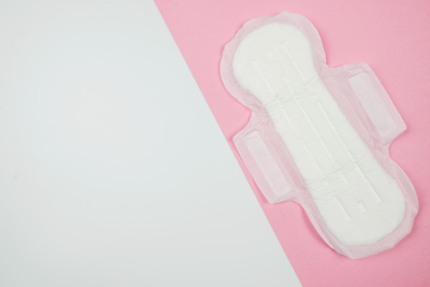 Serviette hygiénique tampon sur fond rose et blanc Menstruation hygiène féminine vue de dessus espace de copie