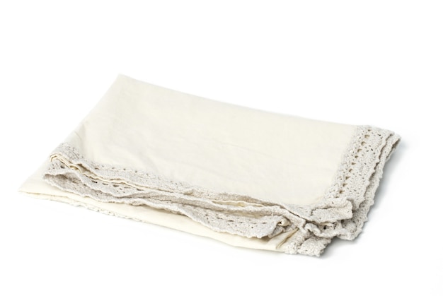 Serviette en lin beige pliée sur fond blanc, vue de dessus