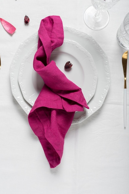 Serviette en lin fuchsia sur le plat blanc