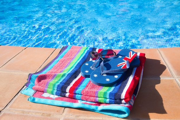 Serviette et sandale près de l'eau bleue de la piscine