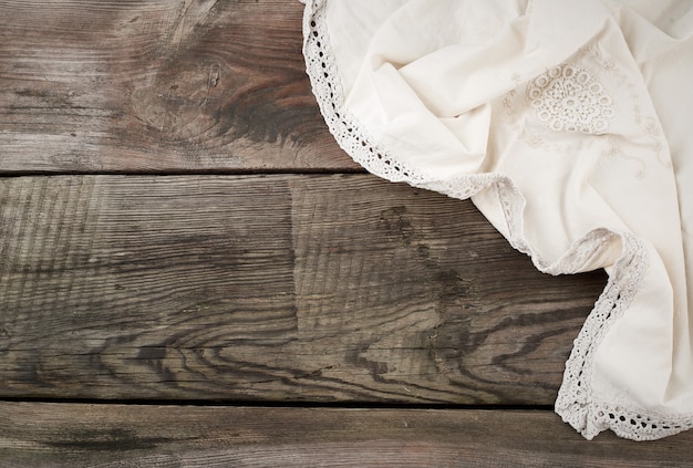 Serviette textile de cuisine blanche pliée sur une table en bois gris