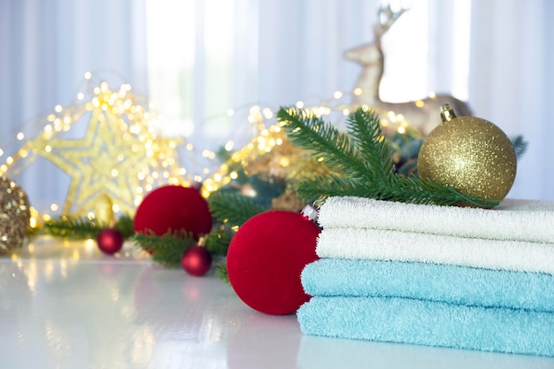 Serviettes bleues et blanches fraîches branches de sapin Lumières de Noël et jouets sur fond Concept de SPA ou de salon de beauté Lavage de linge ou nettoyage à sec en variation de Noël ou du Nouvel An Espace de copie