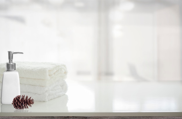 Serviettes et bouteille de savon liquide sur une table blanche avec espace de copie.