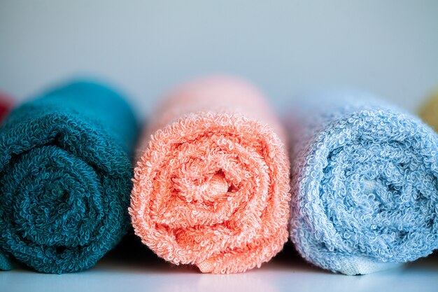 Serviettes colorées sur une table blanche dans la salle de bain.