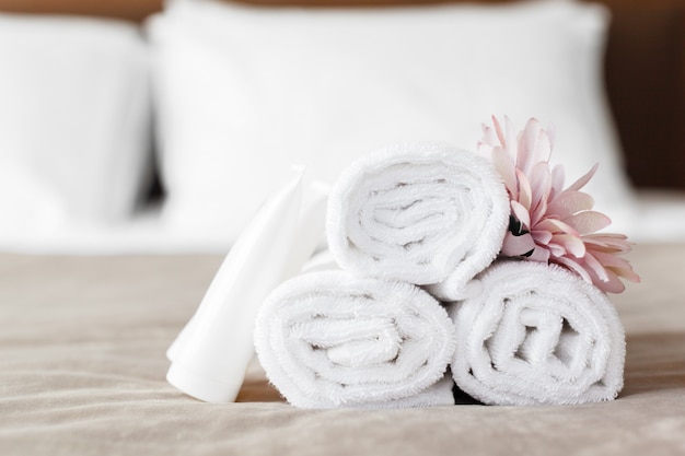 Serviettes et fleurs sur le lit dans la chambre d&#39;hôtel