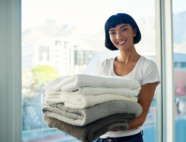 Des serviettes fraîches pour la semaine Photo recadrée d'une jeune femme portant une pile de serviettes le jour de la lessive à la maison