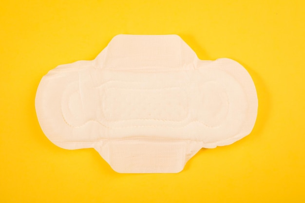 Serviettes hygiéniques et tampon sur fond jaune produits d'hygiène