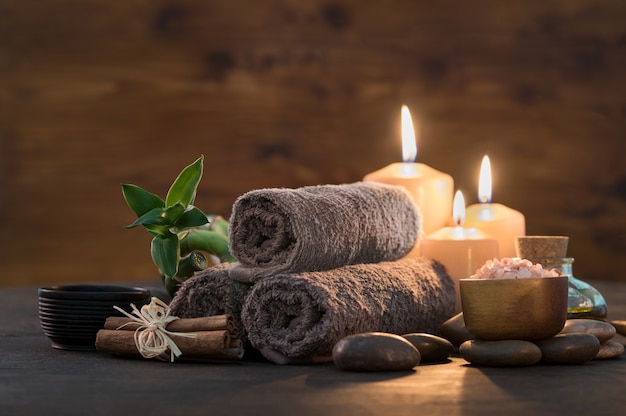 Photo serviettes marron avec bambou et bougies pour un massage relaxant au spa.