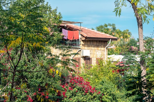 Les serviettes de plage sèchent sur le balcon du grenier dans une ville méditerranéenne parmi la verdure