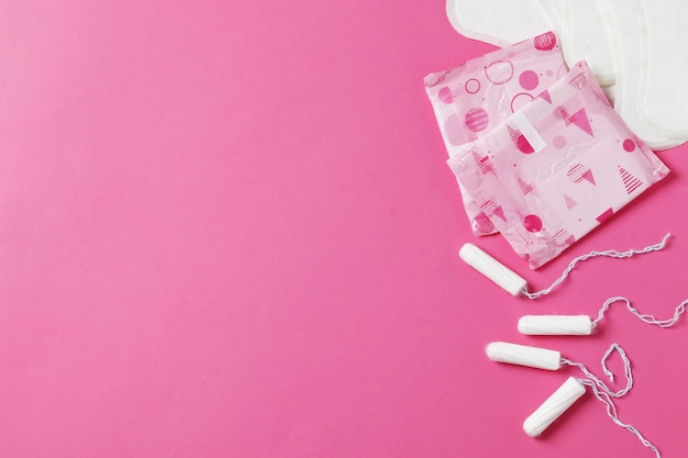 serviettes et tampons sur fond rose. Notion d'ovulation. notion de menstruation.