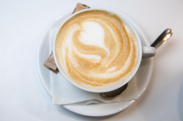 Servir du latte dans un café. Cuillère à serviette tasse et sucre.