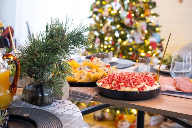 Servir une table festive avec des collations, des salades et des goodies en gros plan dans une maison décorée pour Noël