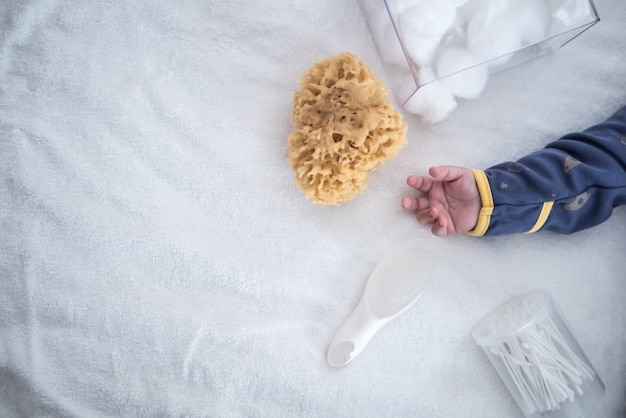 Photo set main et douche bébé à plat sur une couverture blanche