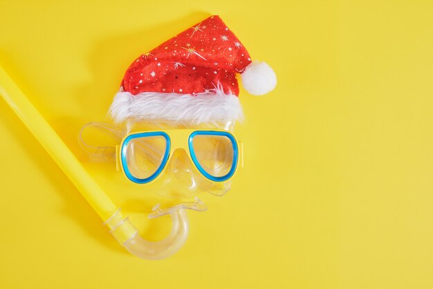 Set de plongée, chapeau de père noël, crème solaire et bouteille de limonade, vacances de Noël sur la plage dans un pays chaud