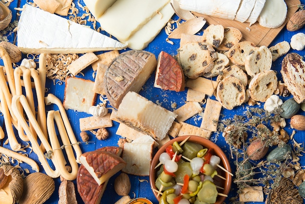 set de table avec un apéritif composé de différents aliments fromages et conserves de cornichons