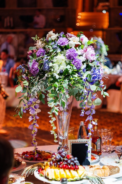 Set de table pour banquet de mariage avec composition florale de dianthus décoratif.