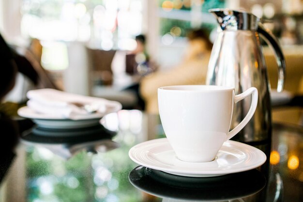 Set de thé après-midi anglais comprenant la théière et une tasse de thé sur assiette blanche