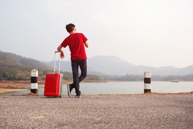 Seul homme debout sur la route avec un sac