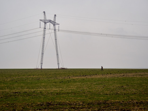 Seul support de pylône électrique dans un champ brumeux