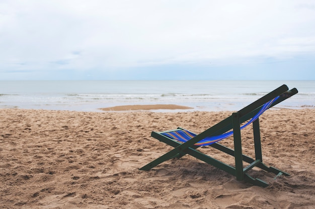 Une seule chaise de plage au bord de la mer avec fond de ciel bleu