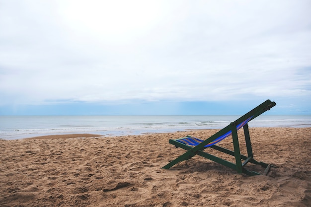 Une seule chaise de plage au bord de la mer avec fond de ciel bleu