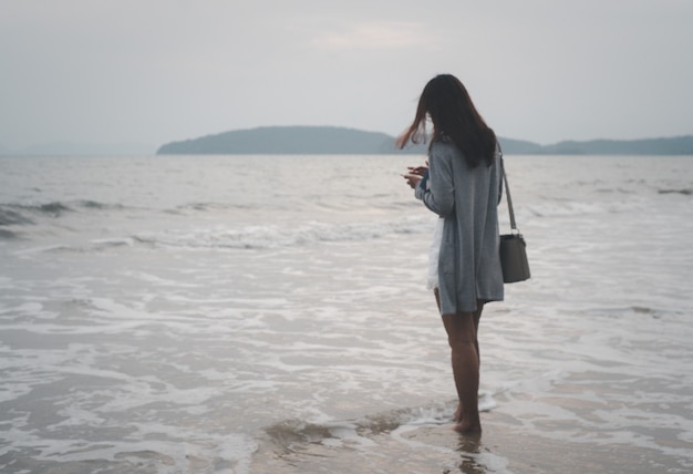 Seule Femme Marchant Seule Réfléchissant Sur La Surface De La Plage Sur Un Fond Orageux Sur La Mer