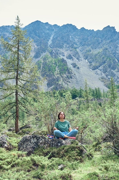 Seule Femme De Taille Plus Assise Sur Une Pierre Et Méditant Haut Dans Les Montagnes Calme Et Unité Avec La Nature