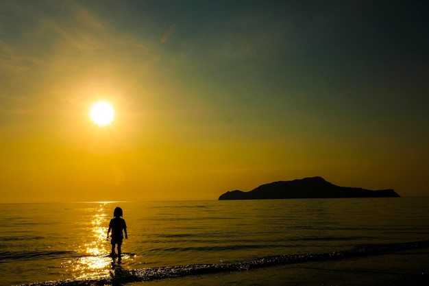 Seule fille debout sur la plage avec la lumière du soleil sur les vacances d&#39;été.