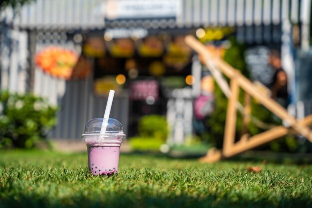 Photo une seule tasse de thé à bulles sur de l'herbe verte