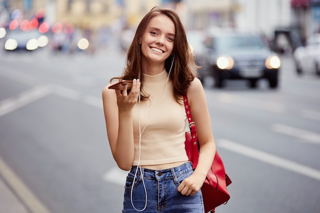 Sexy jeune femme heureuse parle par téléphone à l'extérieur