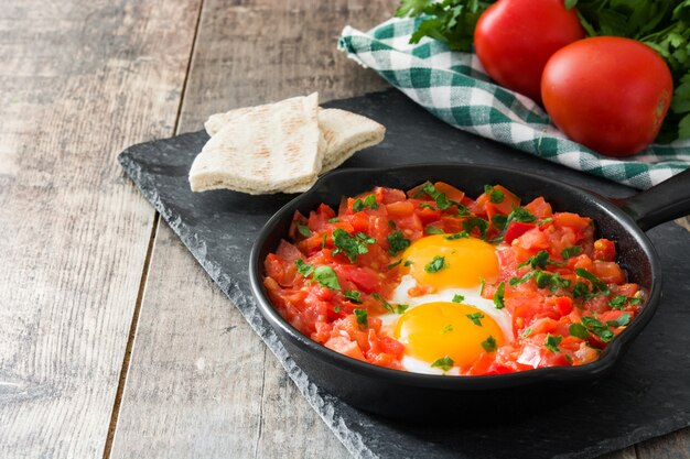 Shakshuka dans une poêle en fer sur une table en bois Un plat typique d'Israël.