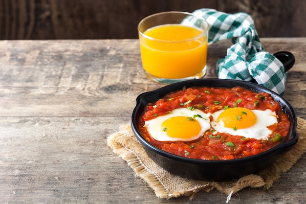 Shakshuka dans une poêle à frire en fer sur une table en bois Nourriture typique en Israël