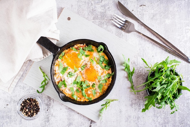 Shakshuka avec tomates et roquette dans une casserole Plat méditerranéen traditionnel Vue de dessus