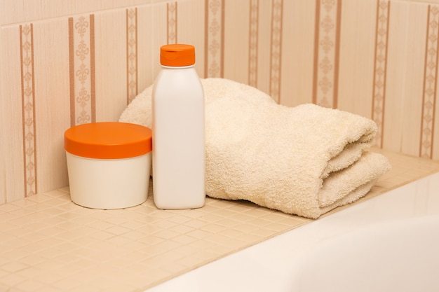 Shampooing naturel, après-shampooing et serviette de bain dans une salle de bain