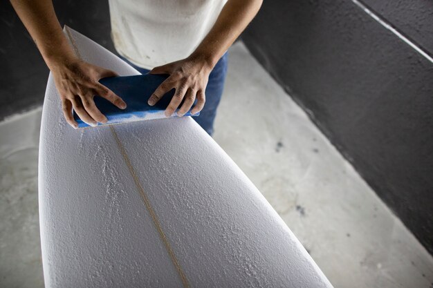 shaper modélisant une nouvelle planche de surf