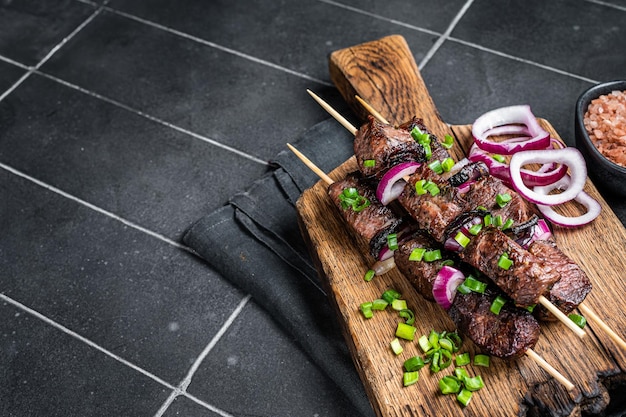 Shashlik brochettes de viande grillée shish kebab avec viande de boeuf et d'agneau oignon et herbes Fond noir Vue de dessus Espace de copie