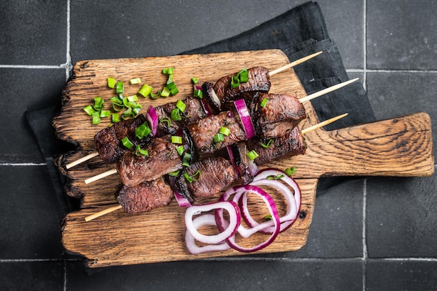 Shashlik brochettes de viande grillée shish kebab avec viande de boeuf et d'agneau oignon et herbes Fond noir Vue de dessus