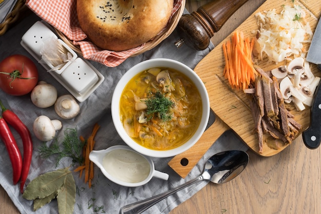 Shchi à La Crème Sure - Une Soupe De Légumes Traditionnelle Russe Faite De Chou, Pommes De Terre, Carottes Et Champignons Dans Une Assiette Avec Un Traditionnel Ouzbek