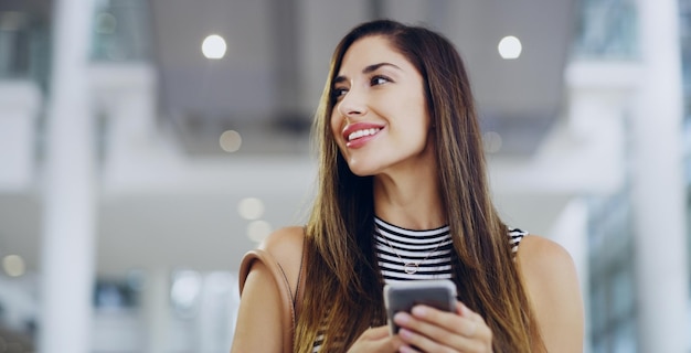 Shes a eu une idée recadrée d'une jeune femme d'affaires à l'aide d'un smartphone tout en marchant dans un mois