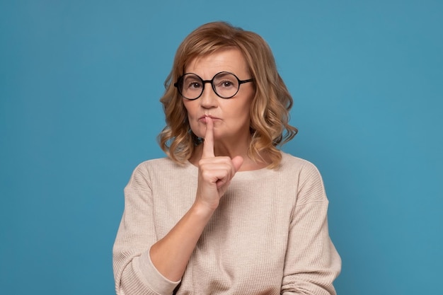 Shh Gardez le concept de silence Femme sérieuse dans des verres gesticulant signe de silence