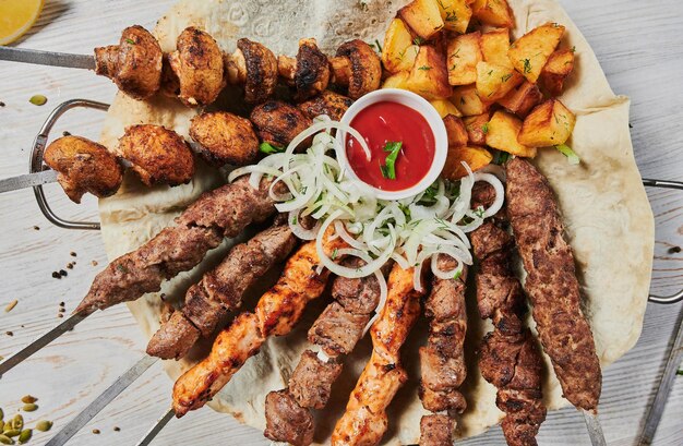 Photo shish kebab d'agneau avec des légumes sur une planche de bois