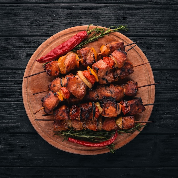 Shish kebab sur des brochettes avec des oignons sur la table en bois noir