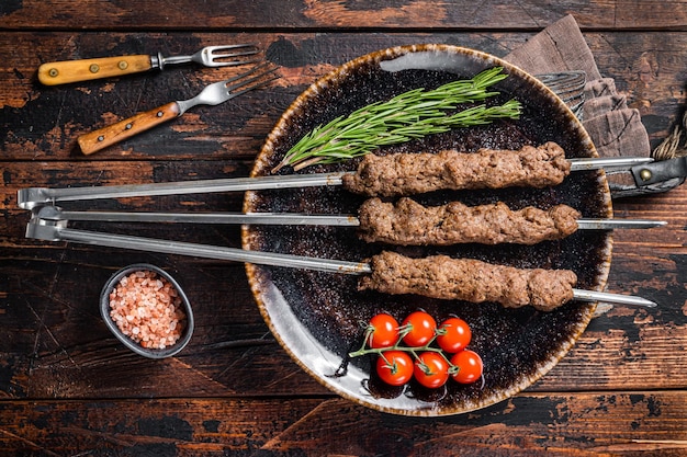 Shish kebab grillé sur des brochettes de viande hachée de boeuf d'agneau, Lula kebab. Fond en bois. Vue de dessus.