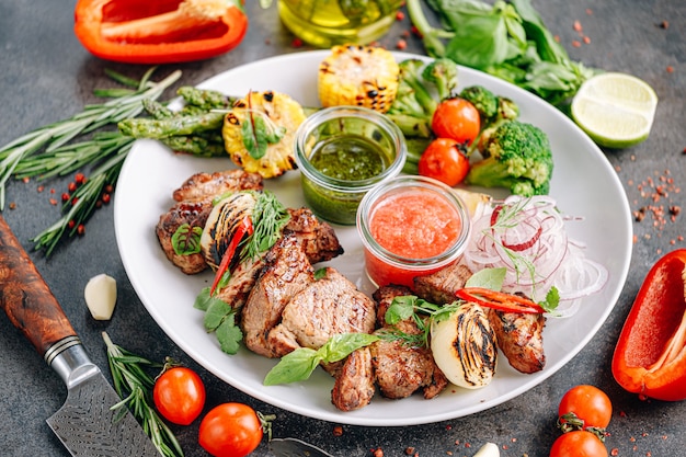 Shish kebab et légumes grillés et servis sur une assiette blanche