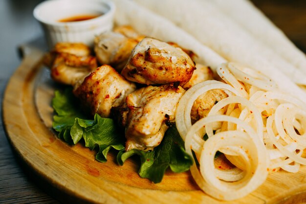 Shish kebab avec rondelle d&#39;oignon et lavash sur la plaque de bois.