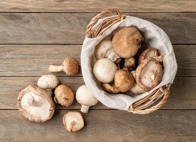 Shitake portobello et champignons de paris dans un panier sur une table en bois