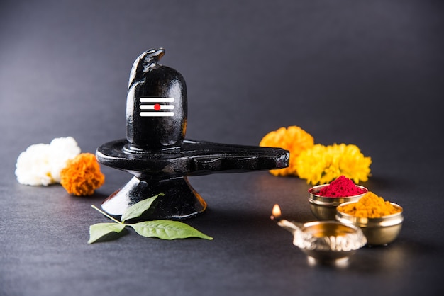 Shiva Linga décoré de fleurs et bel patra ou feuille et haldi kumkum pour Pooja ou adoration de Lord shiva ou Shankar bhagwan