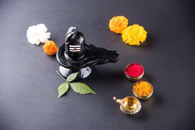 Photo shiva linga décoré de fleurs et bel patra ou feuille et haldi kumkum pour pooja ou adoration de lord shiva ou shankar bhagwan